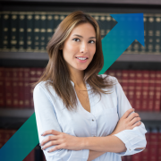 A woman in a blouse stood in front of law books, smiling, chartered corporate commercial surveyor, business rates assessment